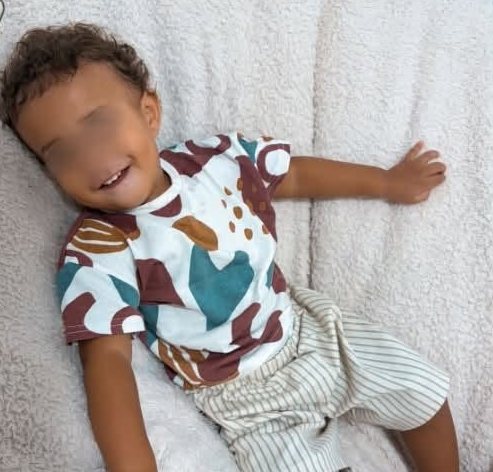Un petit garçon souriant allongé sur un plaid tout doux